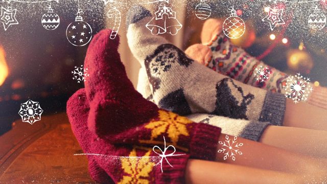Personen mit warmen Weihnachtssocken vor festlicher Dekoration – Weihnachtsvideo für Unternehmen